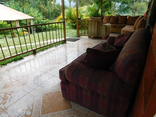 a living room with a couch on a patio at Casa Campo alojamiento campestre para descanso en Calarcá Quindío in Potosí