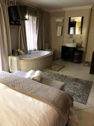 a bathroom with a tub and a bed and a sink at Annie's Place in Kempton Park