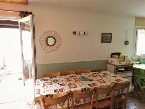 a dining room with a table with chairs and a kitchen at Vaqué Villeneuve des Escaldes Angoustrine in Angoustrine
