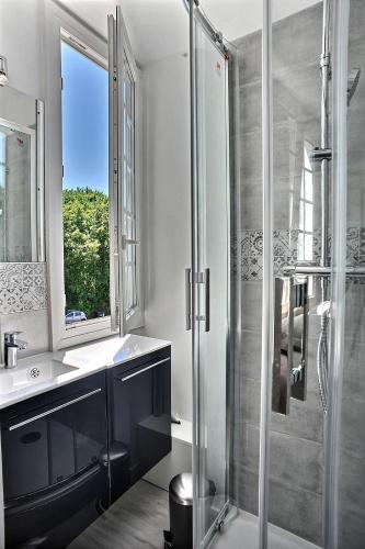 une salle de bain avec une douche et un lavabo et une fenêtre dans l'établissement Les Terrasses du parc Cordier, à Trouville-sur-Mer