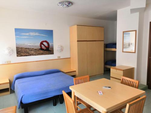 1 dormitorio con cama, mesa, mesa y sillas en Appartamenti Vanin, en Cavallino-Treporti