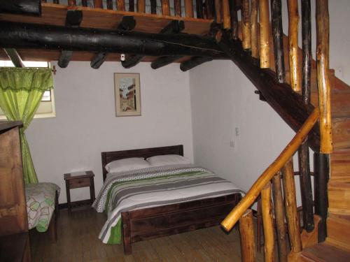 a bedroom with a bed in a room with a staircase at Spa Posada 4 Esquinas in La Uvita
