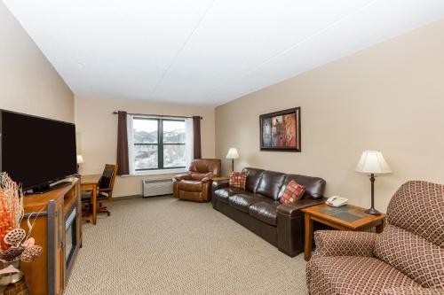 a living room with a couch and a flat screen tv at Travelodge by Wyndham Deadwood in Deadwood