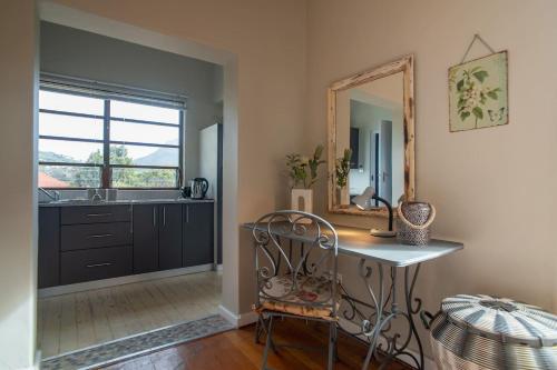 a room with a mirror and a table and a sink at 11 Deerpark Drive East in Cape Town