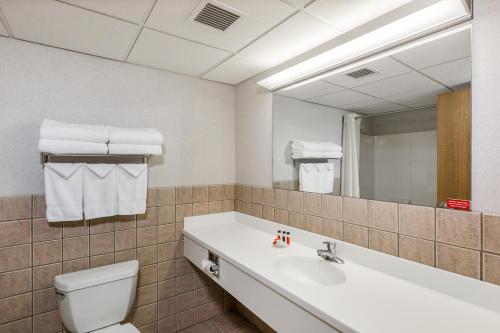 a bathroom with a sink and a toilet and a mirror at Travelodge by Wyndham Deadwood in Deadwood