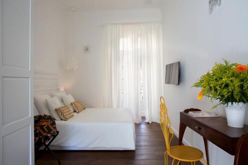 ein weißes Schlafzimmer mit einem Bett, einem Schreibtisch und einem Schreibtisch in der Unterkunft Domus Sansevero in Neapel