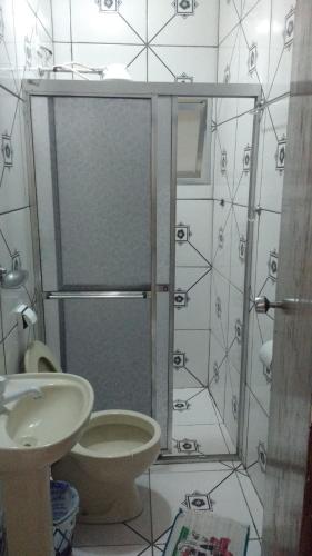 a bathroom with a shower with a toilet and a sink at Pousada Brilho do Sol in Guarujá