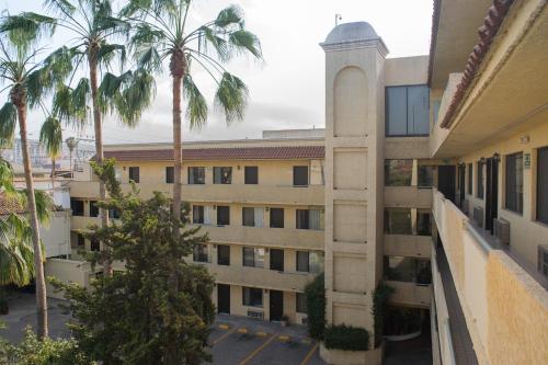 an apartment building with palm trees in the courtyard at Hotel America in Tijuana