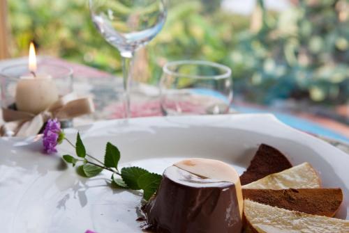 a plate of food on a table with a candle and wine glasses at Hotel Gallo Nero in SantʼAndrea