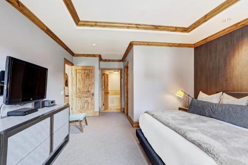 a bedroom with a bed and a flat screen tv at The Arrabelle at Vail Square, a RockResort in Vail