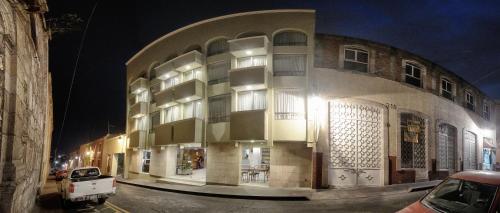 a large building on a city street at night at Hotel Qualitel Plus in Morelia