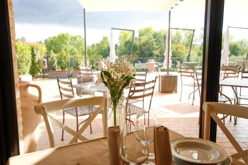 una mesa con un jarrón de flores en un patio en Villa Gens Camuria en Camerano