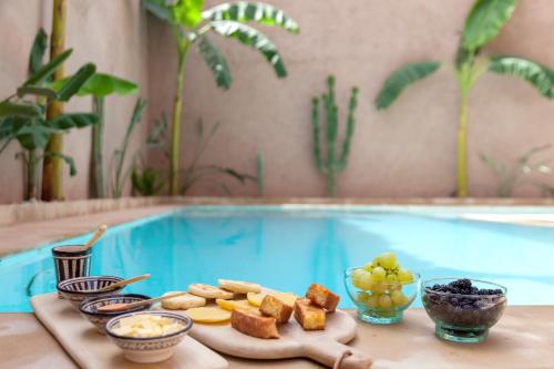 - un plateau de nourriture sur une table à côté de la piscine dans l'établissement Dar Al Walidine, à Marrakech