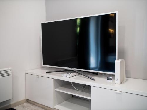 a flat screen tv sitting on a white entertainment center at Lóczy Apartman in Balatonfüred