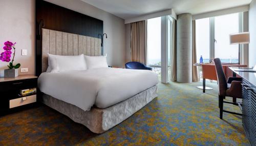 a hotel room with a large bed and a large window at Hotel X Toronto by Library Hotel Collection in Toronto