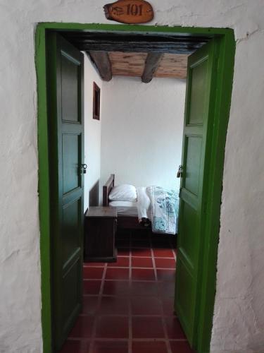 a green door leading to a bedroom with a bed at Spa Posada 4 Esquinas in La Uvita