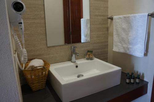 y baño con lavabo blanco y espejo. en Hotel Mirante Tlaxcala en Tlaxcala de Xicohténcatl