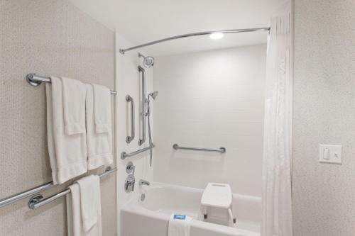 a bathroom with a tub and a shower with towels at Holiday Inn Express West Los Angeles by IHG in Los Angeles