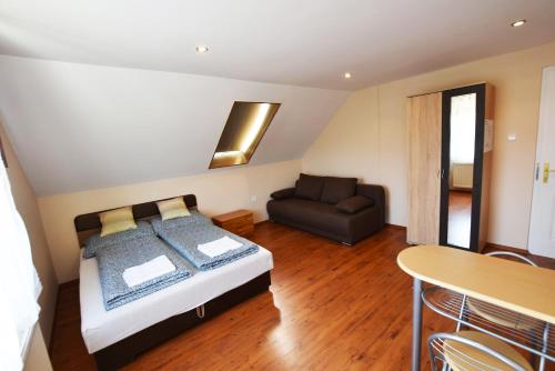 a bedroom with a bed and a couch at Hőforrás Wellness Vendégház in Egerszalók