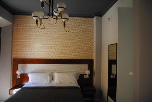 a bedroom with a large bed with a wooden headboard at Pensión Córdoba in Seville