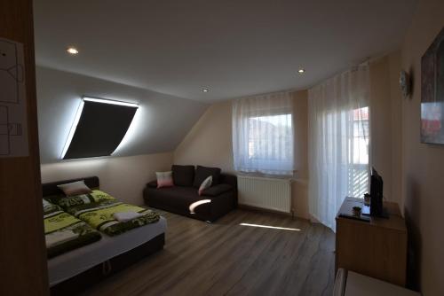 a living room with a bed and a couch at Hőforrás Wellness Vendégház in Egerszalók
