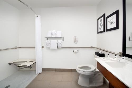 a white bathroom with a toilet and a sink at Country Inn & Suites by Radisson, Houston Intercontinental Airport East, TX in Humble