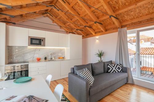 ein Wohnzimmer mit einem Sofa und einem Tisch in der Unterkunft Indulge Porto Flats in Porto