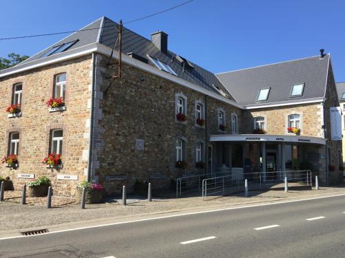 a large brick building on the side of a street at La Couronne in Welkenraedt