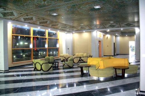 a lobby with tables and chairs in a building at Melian Hotel in An Najaf