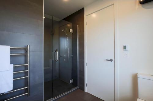 La salle de bains est pourvue d'une douche avec une porte en verre. dans l'établissement Diamond On Tenby, à Wanaka