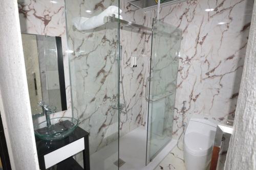 a bathroom with a glass shower and a toilet at Melian Hotel in An Najaf