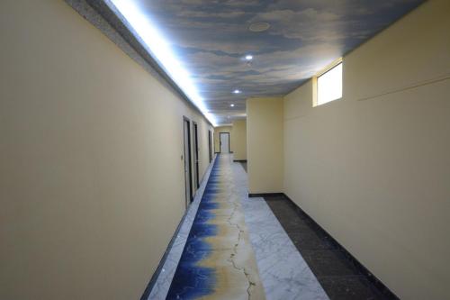 an empty hallway with a long aisle in a building at Melian Hotel in An Najaf