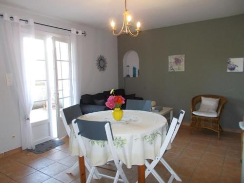 - un salon avec une table et un vase de fleurs dans l'établissement Vacances Vaison la Romaine, à Vaison-la-Romaine