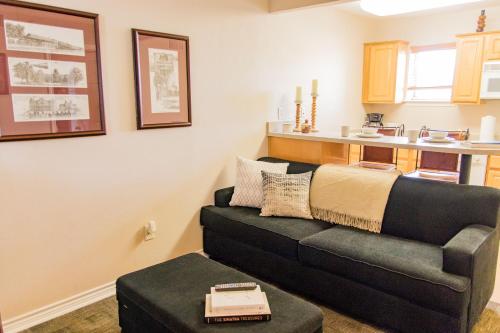 a living room with a couch and a table at Vineyard Court Designer Suites Hotel in College Station