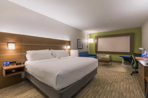 a hotel room with a large bed and a projection screen at Holiday Inn Express & Suites - San Marcos South by IHG in San Marcos
