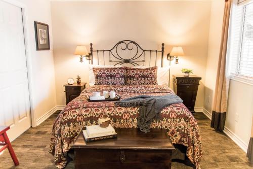 a bedroom with a bed with a wooden table at Vineyard Court Designer Suites Hotel in College Station