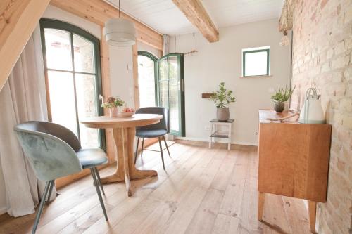 a kitchen with a table and chairs in a room at Scheune de Lütt - Kleine Scheune ganz groß am Rande der Schorfheide - Natur pur in Marienwerder