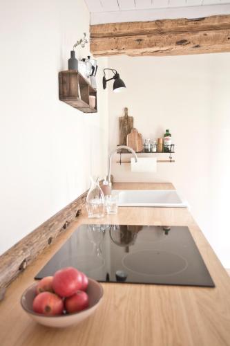 a kitchen with a sink and a bowl of fruit at Scheune de Lütt - Kleine Scheune ganz groß am Rande der Schorfheide - Natur pur in Marienwerder