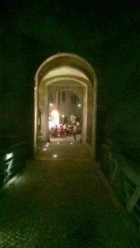 an archway with a person walking through it at night at Atirano in Tirano