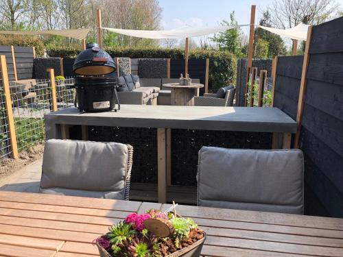 a patio with a table and chairs and a grill at 't Veldehof in Domburg