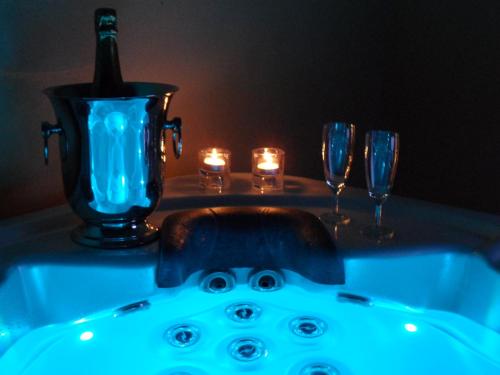 a bath tub with a bottle of wine and glasses at Les Grandes Terres - Gîtes & SPA in Mérindol