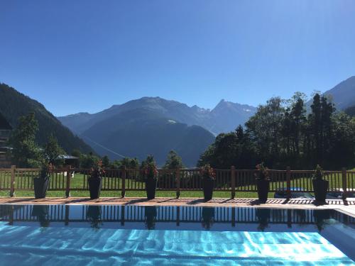 a swimming pool with mountains in the background at Olympia-Relax-Hotel Leonhard Stock in Finkenberg