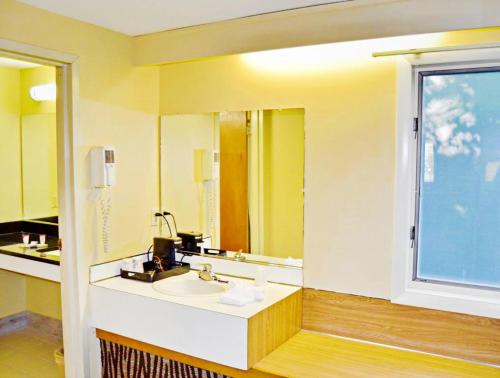 a bathroom with a sink and a mirror at Flagship Inn & Suites in Groton