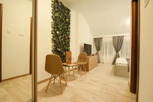 a living room filled with furniture and a tree at Korzo apartmani in Podgorica