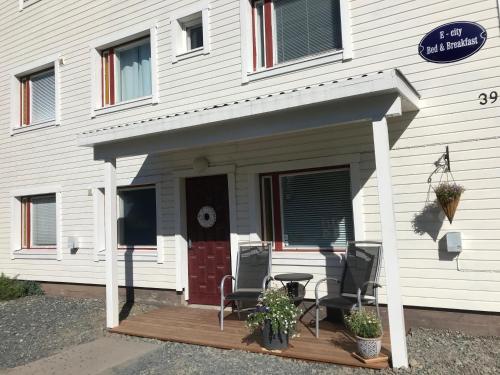 a house with a porch with two chairs and a table at E-City B&B in Tornio