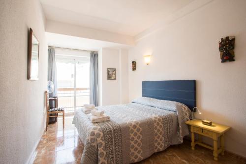 1 dormitorio con 1 cama con cabecero azul en Alicante central and beach side apartment, en Alicante