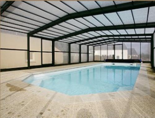 a large swimming pool in a large building at Auberge Saint Hernin in Pluherlin