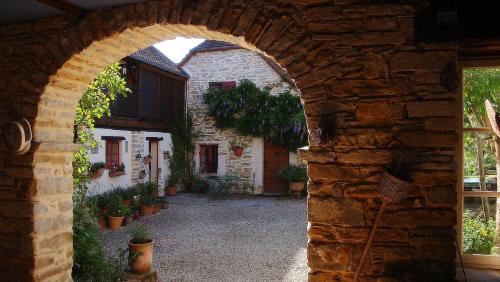 an archway in a stone building with potted plants at Chambres d'Hôtes Secret Pyrenées in Lasseube