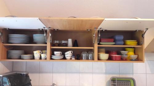 a kitchen shelf with plates and bowls on it at Ferienwohnung Wölfle in Friesenheim