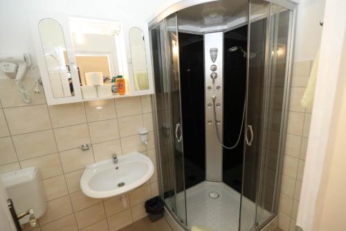 W łazience znajduje się prysznic i umywalka. w obiekcie Hotel California w Budapeszcie